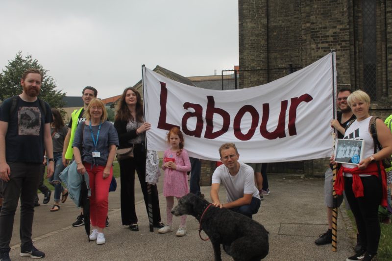 Nine members of Colchester Labour standing in front of the Labour Banner